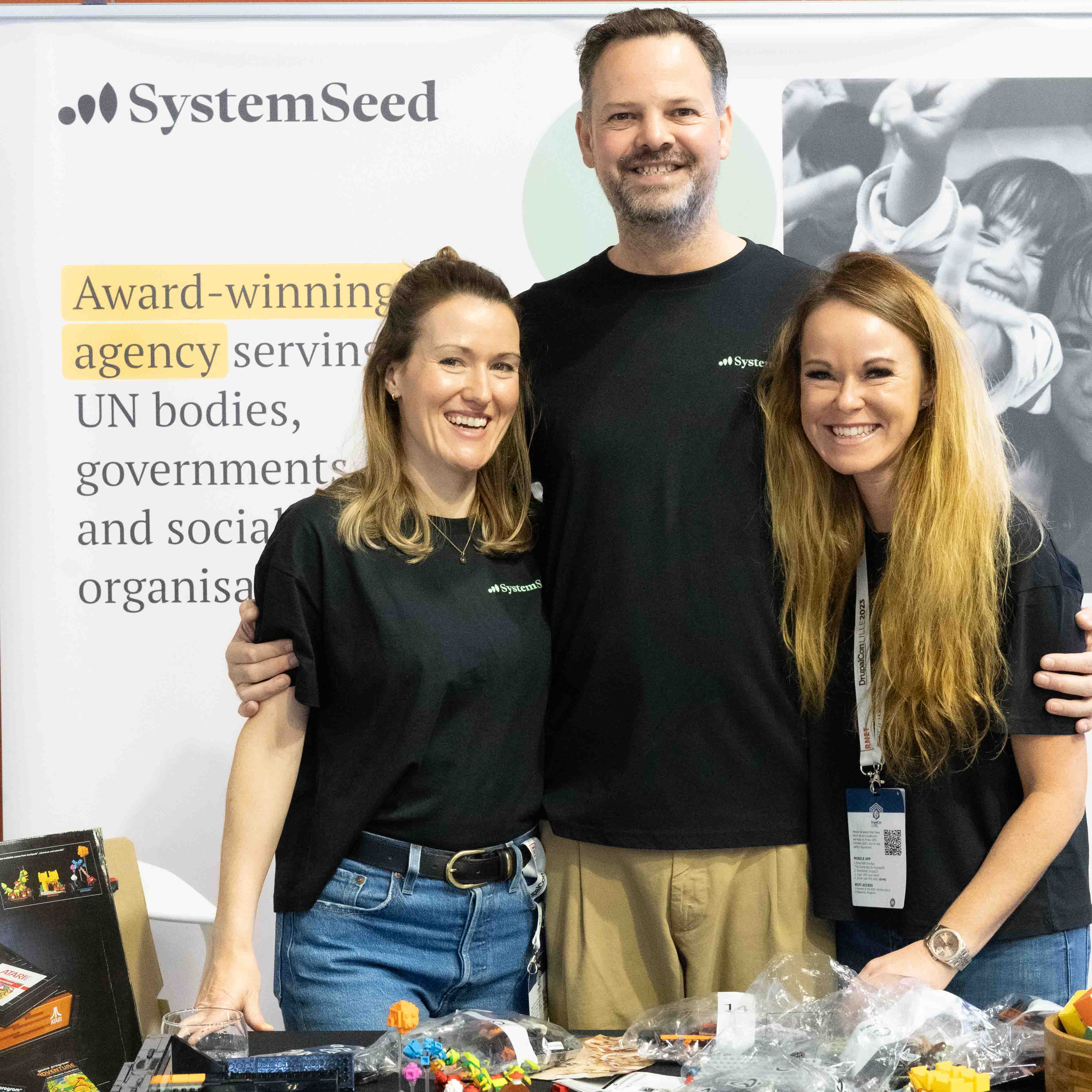 3 white people smiling at a conference 
