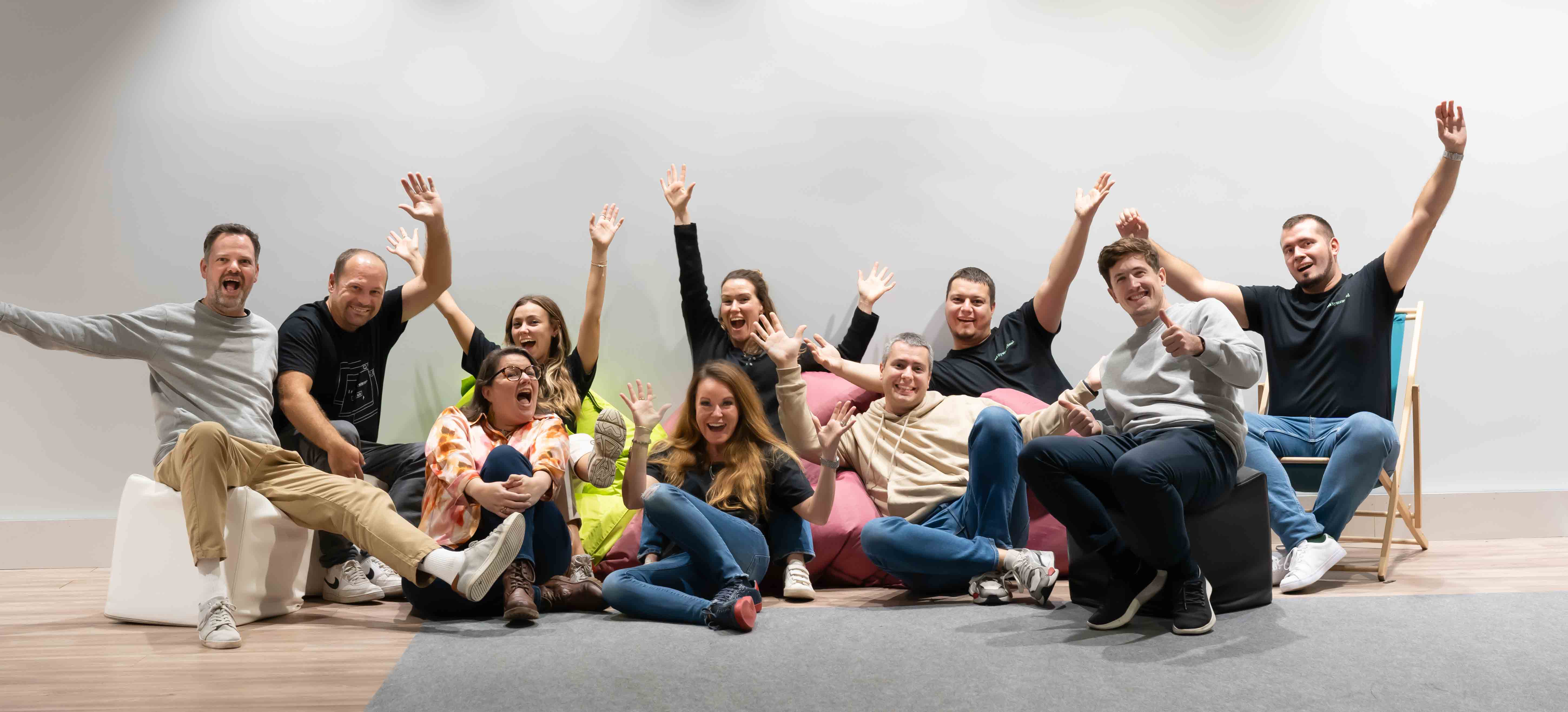 Team of eleven chearing people posing for group portrait 