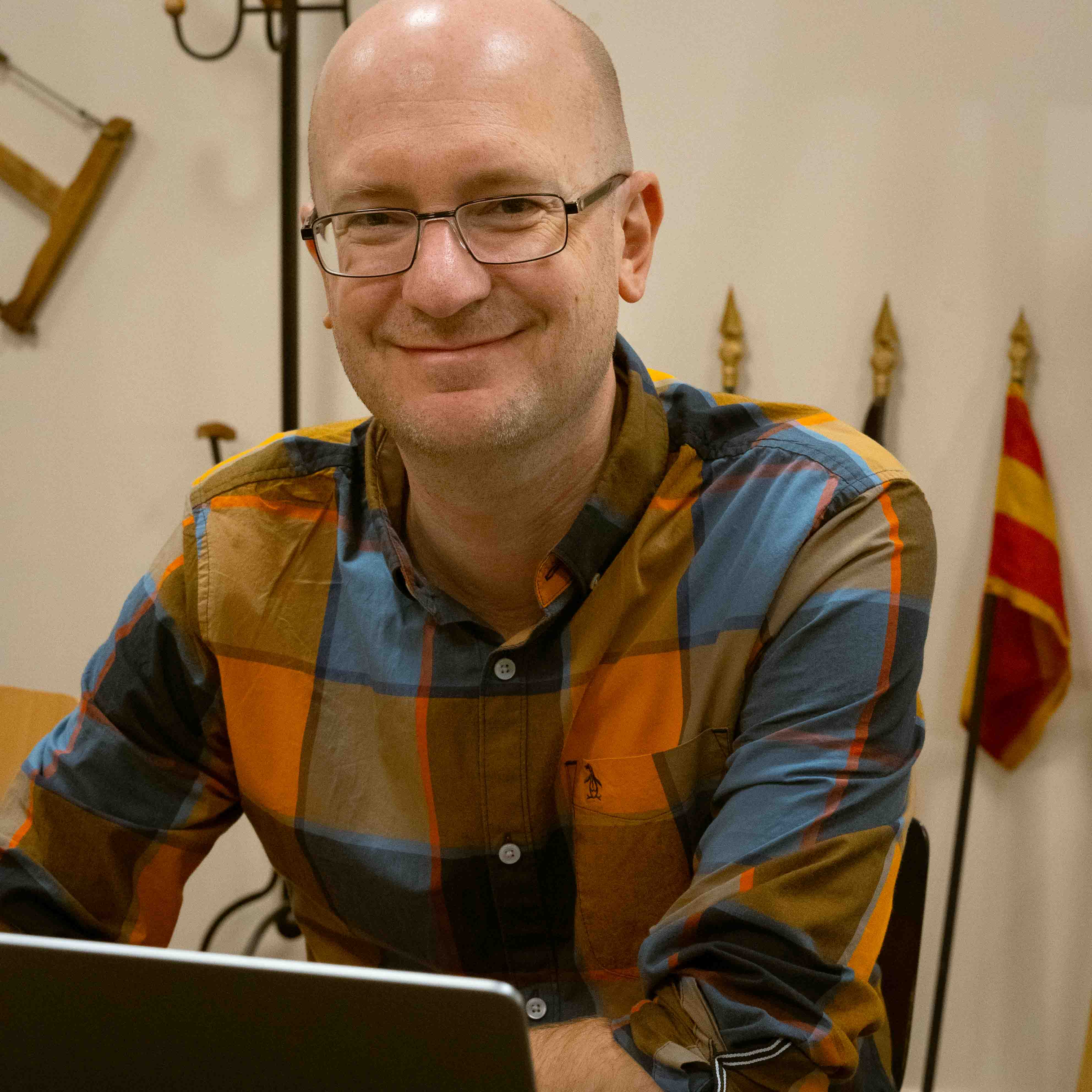 White man engineer sittiing in front of laptop smiling