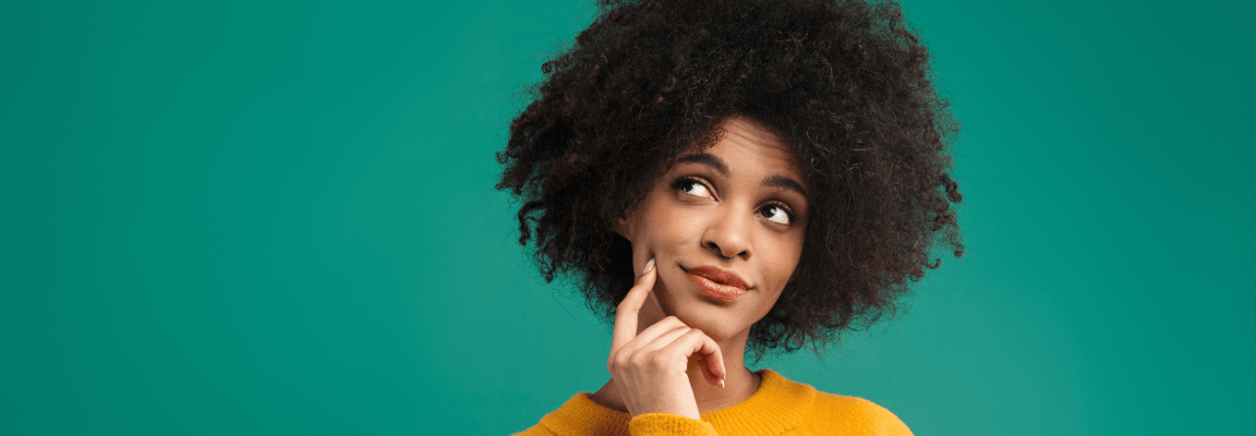Reasons to upgrade from Drupal 7 now A young black woman with natural hair wears a yellow jumper and looks thoughtfully upwards